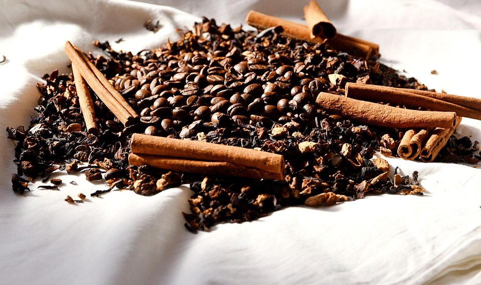 Cinnamon sticks and coffee beans on fabric.