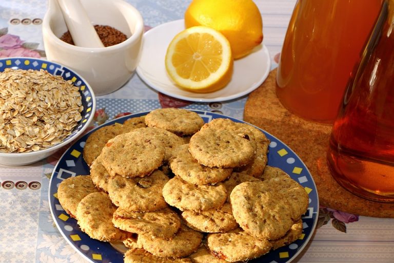 Oatmeal cookies on a plate with lemons and honey ingredients.