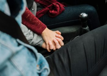 Couple holding hands in a car, expressing love and connection.