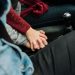 Couple holding hands in a car, expressing love and connection.