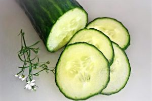 Sliced cucumber with flowers on a white background.