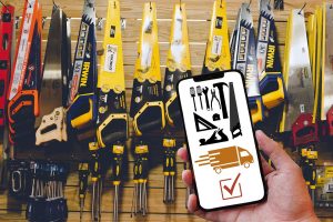 Hand holding phone with tools and delivery app in hardware store.
