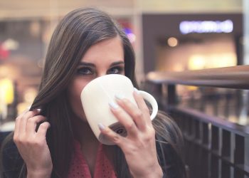 Young woman sipping coffee in a cafe.