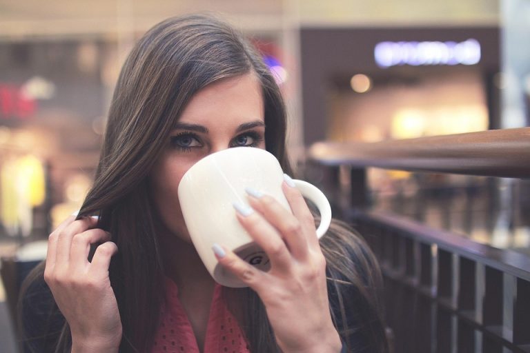 Young woman sipping coffee in a cafe.