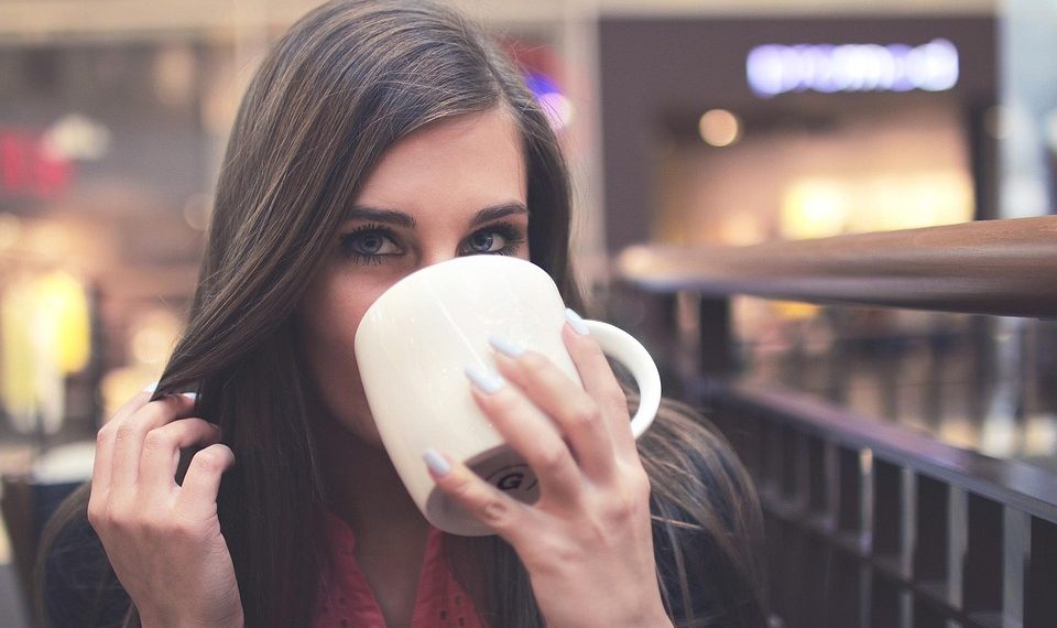 Young woman sipping coffee in a cafe.