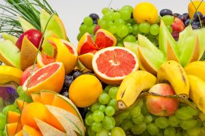 Fresh assorted fruits with vibrant colors, featuring grapes, oranges, and bananas.