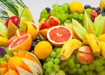 Fresh assorted fruits with vibrant colors, featuring grapes, oranges, and bananas.