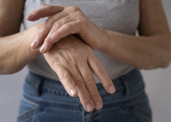 Hands clasping wrist in discomfort.