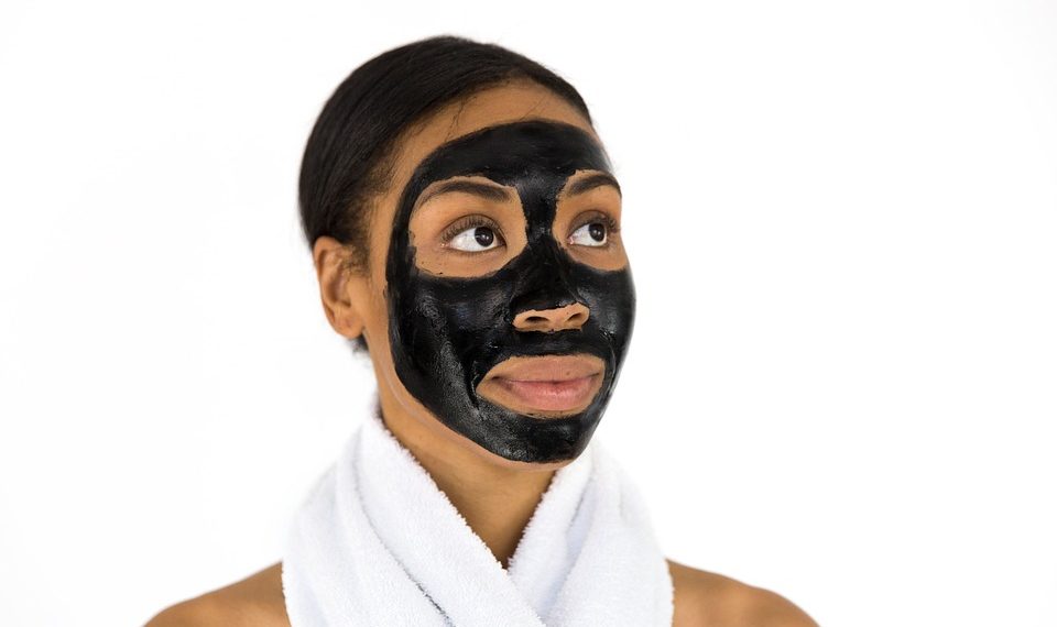 Woman with black face mask and towel around neck.