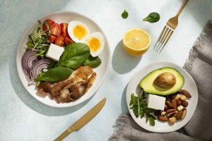 Healthy keto meal with eggs, bacon, avocado, nuts, and vegetables.