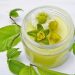 Herbal salve in a jar with fresh flowers and leaves.