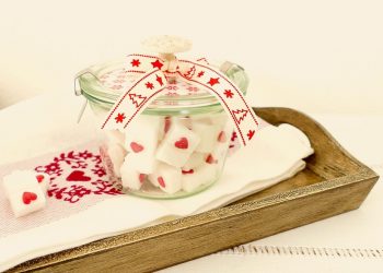Jar of decorative heart sugar cubes with a festive ribbon.