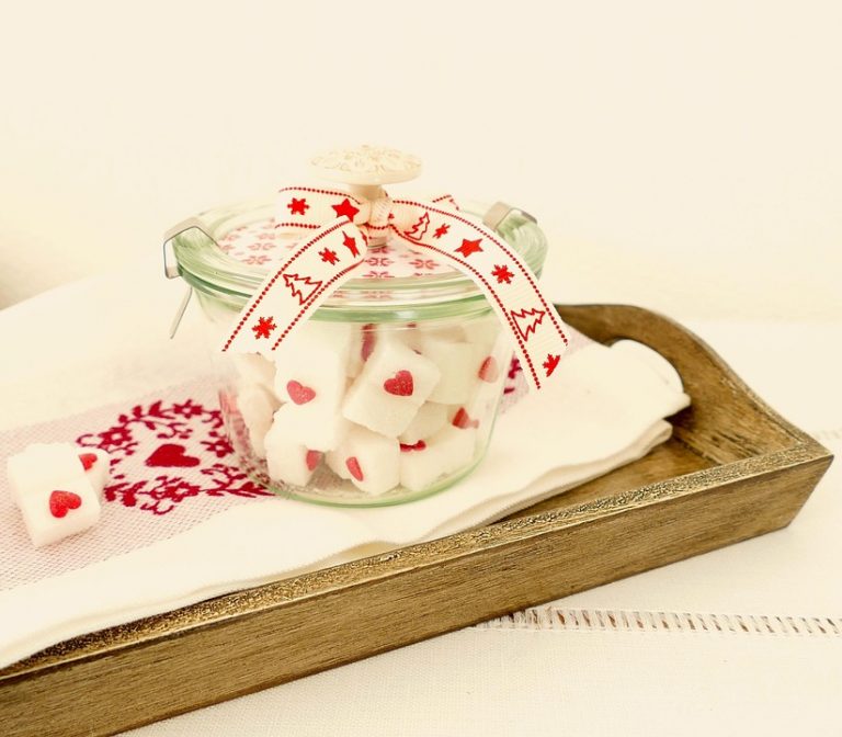 Jar of decorative heart sugar cubes with a festive ribbon.