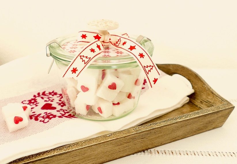 Jar of decorative heart sugar cubes with a festive ribbon.