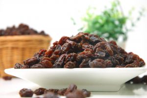 Plate of dried raisins on a table.