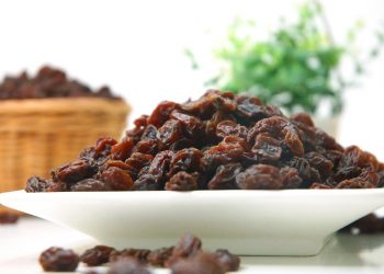 Plate of dried raisins on a table.