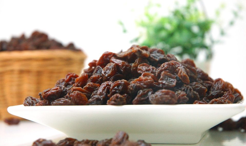 Plate of dried raisins on a table.