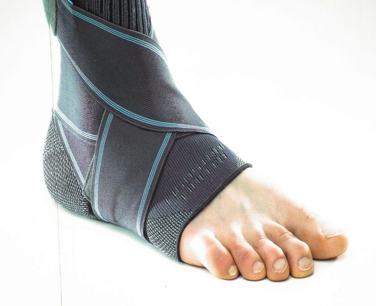 Ankle support brace on a foot providing compression.