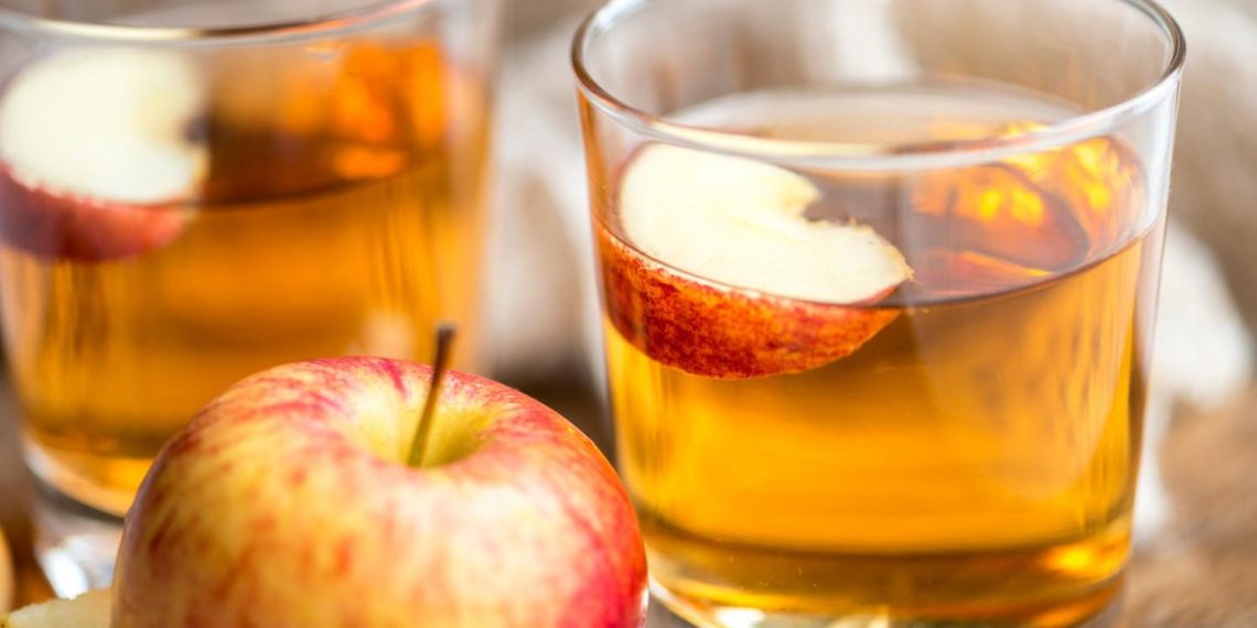 Apple juice in glasses with fresh apple slices.