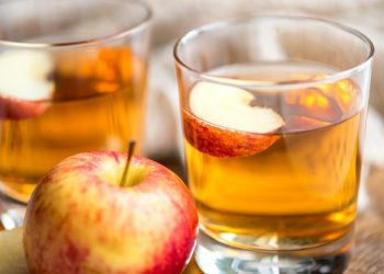 Apple juice in glasses with fresh apple slices.