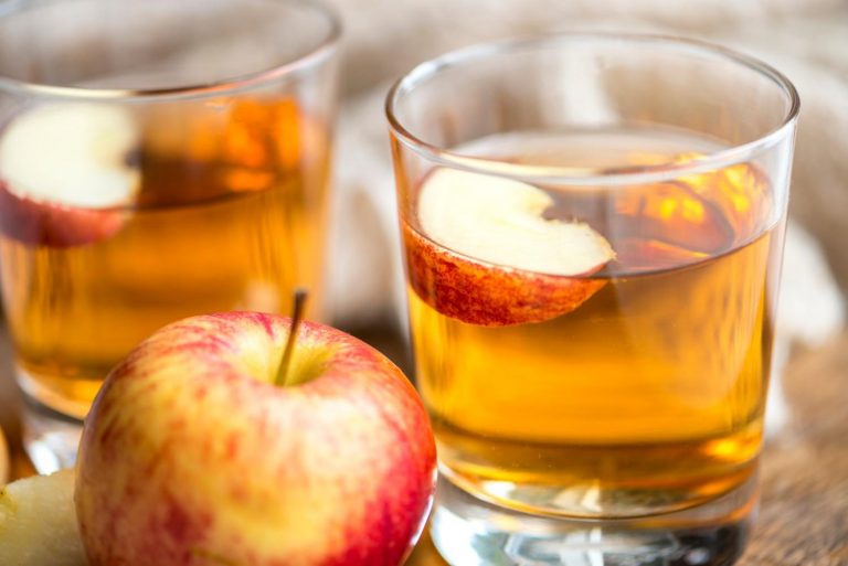 Apple juice in glasses with fresh apple slices.