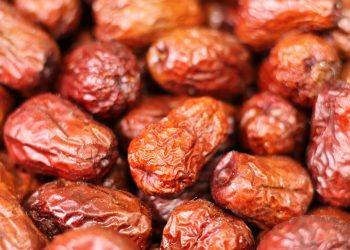 Dried dates piled closely, showcasing their rich brown color.