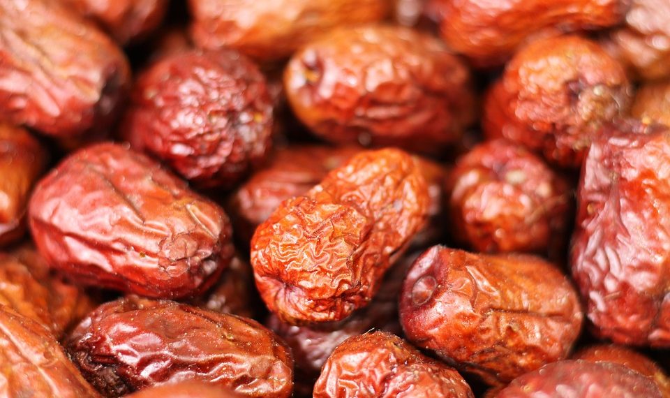 Dried dates piled closely, showcasing their rich brown color.