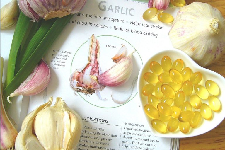 Garlic bulbs and supplement capsules on a health benefits page.