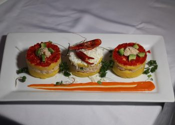 Peruvian causa with crab and avocado garnished with lobster.