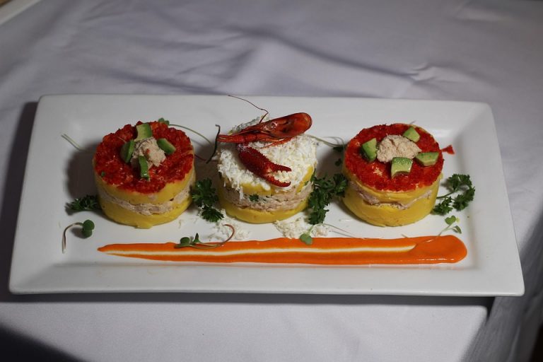 Peruvian causa with crab and avocado garnished with lobster.