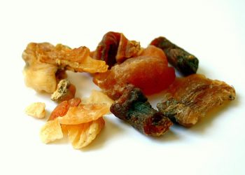 Various dried frankincense resins scattered on a white surface.