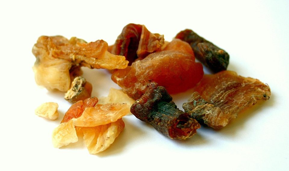 Various dried frankincense resins scattered on a white surface.