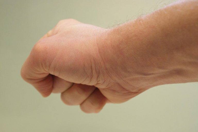 Fist clenched in a neutral background.