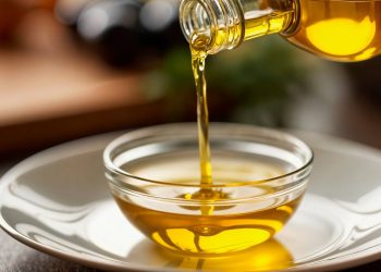 Pouring olive oil into a glass bowl.