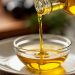 Pouring olive oil into a glass bowl.