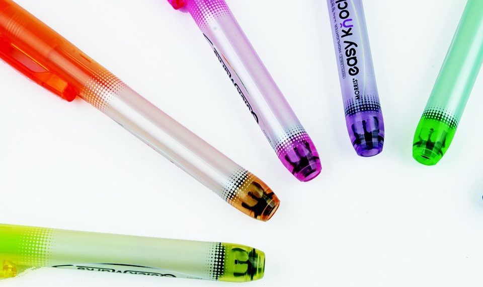 Colorful gel pens arranged in a circle pattern on a white background.