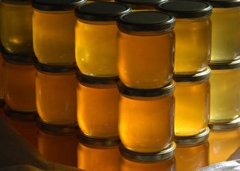 Jars of honey stacked in rows.