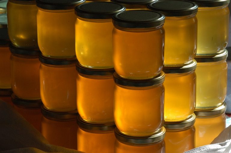 Jars of honey stacked in rows.