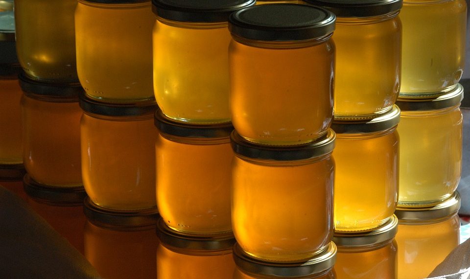 Jars of honey stacked in rows.