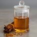 Cinnamon sticks and honey in a glass jar on gray background.