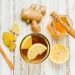 Ginger lemon tea with honey and fresh ginger slices on a wooden table.