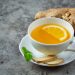 Ginger tea with lemon slice and fresh ginger root.