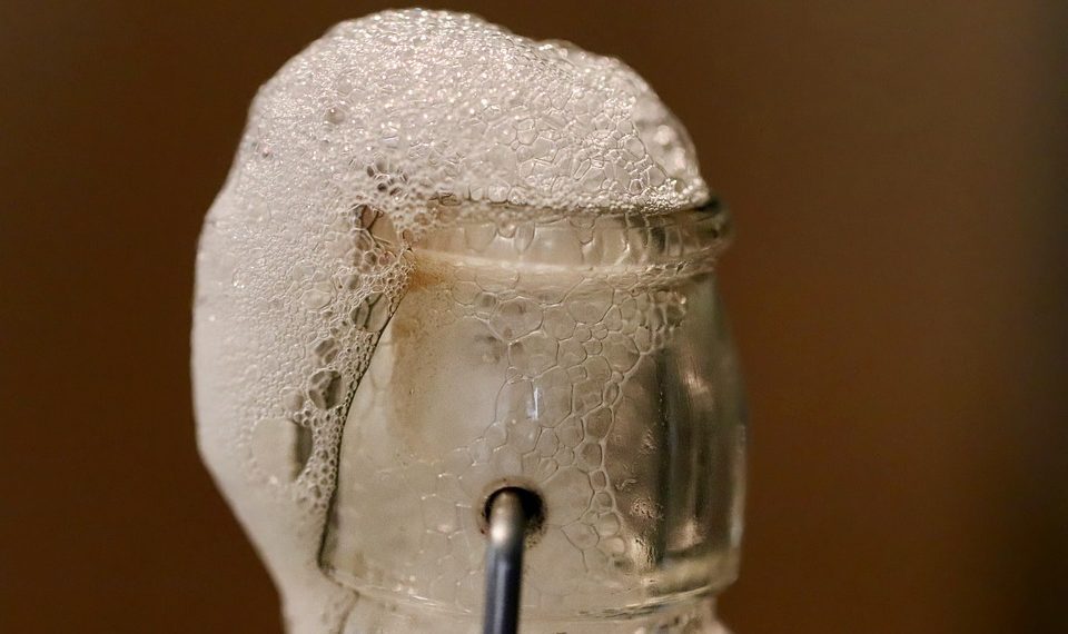 Bubbles overflow on sealed glass bottle.