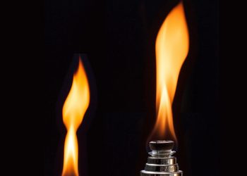 Lit flame on a lighter against a dark background.