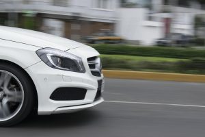 Speeding white car on a city street.