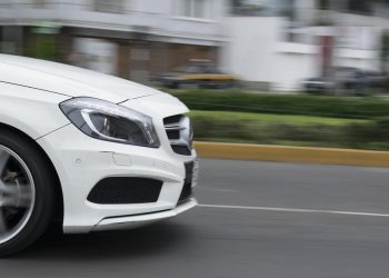 Speeding white car on a city street.