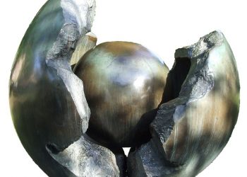 Sculpture of a metallic sphere encased in a cracked shell.