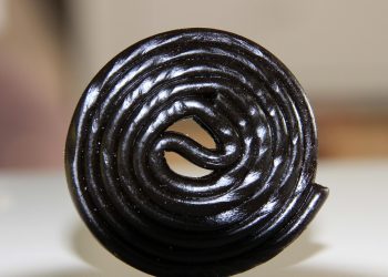 Black licorice wheel candy on a white background.