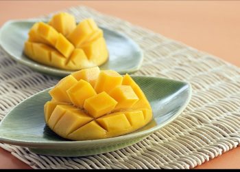 Sliced mangoes on green dishes, ready to serve.
