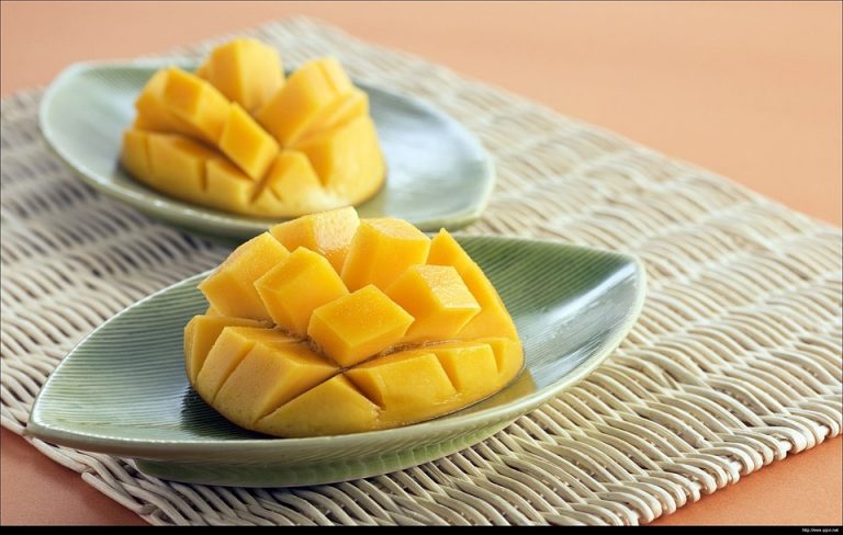 Sliced mangoes on green dishes, ready to serve.